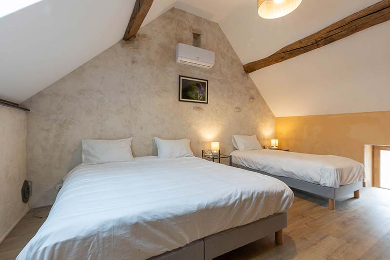 Master bedroom of L'Hirondelle gîte — clay renders and bamboo flooring
